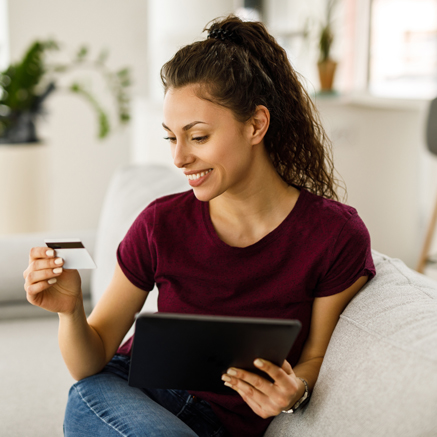 When Online Avoid... Woman with tablet and debit card looking at debit card